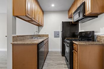 A kitchen with black appliances and wooden cabinets
